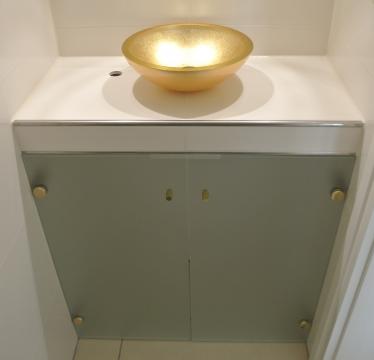 Badschrank unter goldenem Waschbecken 